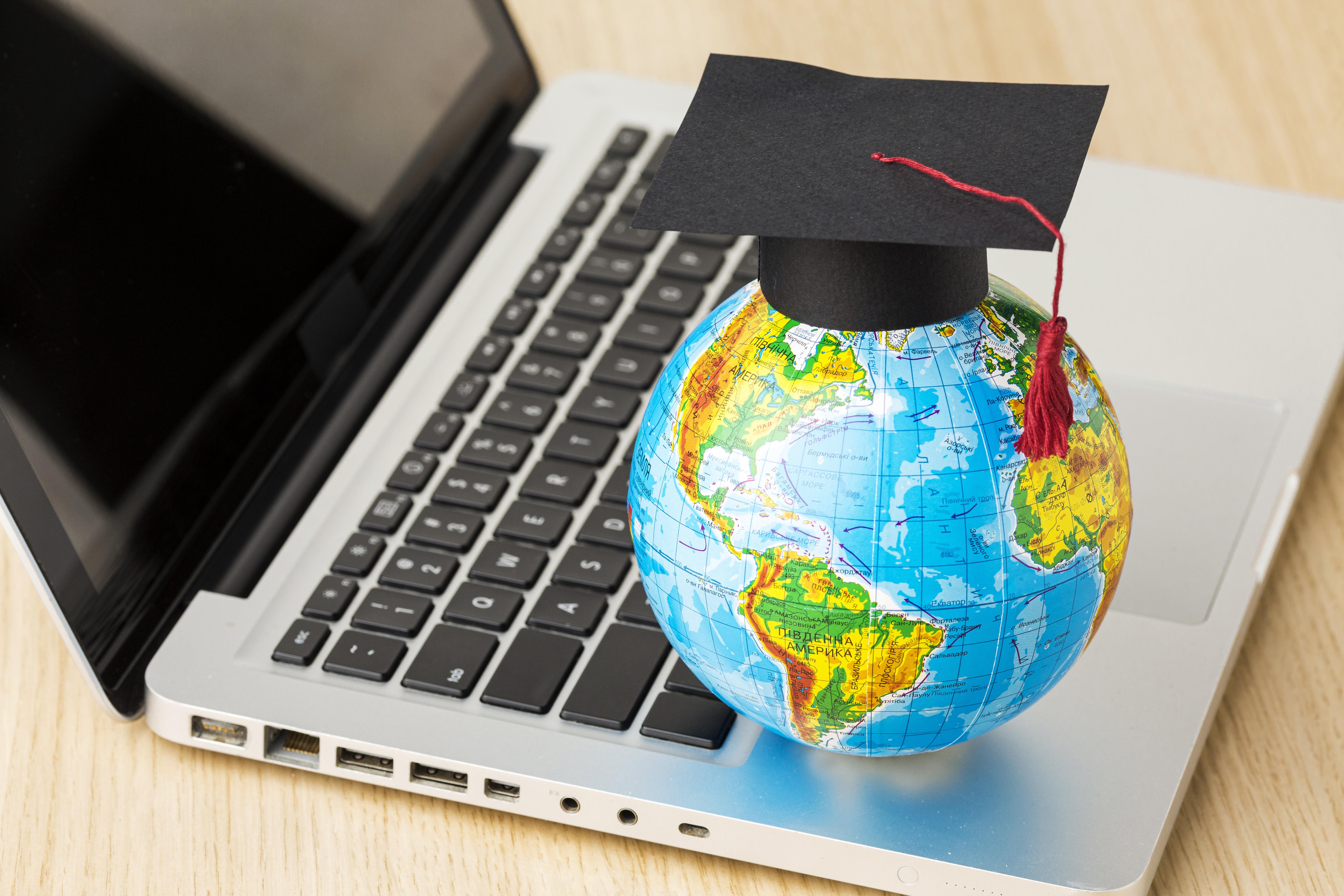 high-angle-globe-with-academic-cap-laptop